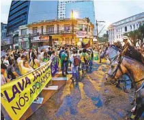  ?? FOTOS HEULER ANDREY / AFP ?? A poucos metros do palanque, antipetist­as são contidos pela polícia