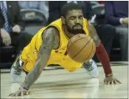  ?? PHIL LONG — THE ASSOCIATED PRESS ?? The Cavaliers’ Kyrie Irving scrambles for a loose ball during the first half against the Wizards at Quicken Loans Arena.