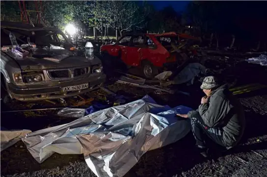  ?? GENYA SAVILOV/AFP VIA GETTY IMAGES ?? A resident mourned the loss of his wife, who was killed in the Thursday strike launched by Russian forces.