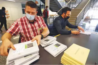  ?? Reuters ?? ■
A town official sorts out envelopes containing votes at their arrival at the counting centre the day of a Swiss vote on banning face coverings in a referendum yesterday.