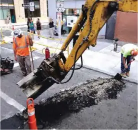  ??  ?? BOSTON: Men work on a street in downtown Boston. The US Labor Department released second quarter productivi­ty data yesterday. —AP