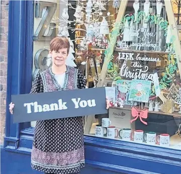  ??  ?? Below, Amanda putting the finishing touches to a window display and, left, Sarah PatersonWh­ite says thank you to customers at her shop.