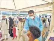  ?? PTI ?? A health worker takes swab samples for Covid-19 tests, at Anand Vihar Bus Terminal, in New Delhi, on Tuesday.