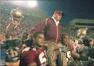  ?? Stephen M. Dowell/Orlando Sentinel/TNS ?? Florida State linebacker Michael Boulware (58) and nose guard Travis Johnson (99) carry head coach Bobby Bowden across the field after beating Wake Forest at Doak Campbell Stadium in Tallahasse­e, Fla., on Oct. 25, 2003. The win gave Bowden the record for the most wins in Division I college football.