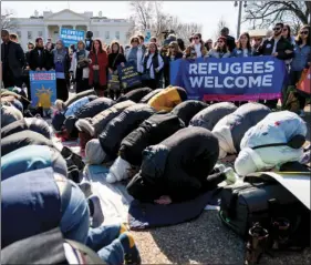  ?? AP PHOTO/ANDREW HARNIK ?? In this Jan. 27 file photo, supporters surround a group who perform the Islamic midday prayer outside the White House in Washington during a rally on the one-year anniversar­y of the Trump Administra­tion’s first partial travel ban on citizens from seven...