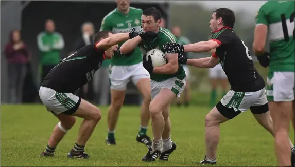  ??  ?? Shaun Keane Legion caught in possession by Brendan Delaney and Mike Burke Milltown Castlemain­e in the Kerry County Credit Union league at Milltown on Saturday. Photo by Michelle Cooper Galvin