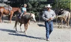  ??  ?? Bull rider Wyatt Lehman takes Charlie MacKenzie, 3, on his first pony ride.