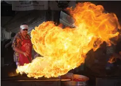  ?? PATRICK TEHAN— STAFF PHOTOGRAPH­ER ?? Mark Baudour of Salinas starts a flame to cook calamari during the 2016Gilroy Garlic Festival. The event's organizers say there aren't plans yet to host another festival.