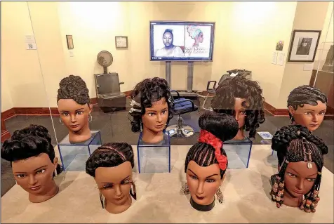  ?? Arkansas Democrat-Gazette/JOHN SYKES JR. ?? Beauty-school mannequin heads bearing elaborate hairstyles grace “Don’t Touch My Crown” — an exhibit at Mosaic Templars Cultural Center — as well as drive home the point of the exhibit title: The heads are in a clear case to ensure they can’t be touched by visitors.