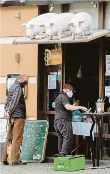  ?? Foto: Petr Topič, MAFRA ?? Tři prasátka Hospody se snaží vydělat aspoň výdejem jídla z okének a dveří. U Tří Prasátek v Praze se tvořila včera fronta.