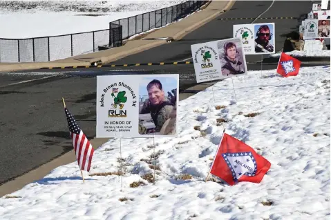  ?? The Sentinel-Record/File photo ?? ■ Signs in honor of U.S. Navy SEAL Chief Petty Officer Adam Brown and other fallen military personnel line the route of the Adam Brown Shamrock Run on March 12, 2022, on the Lake Hamilton School District campus.
