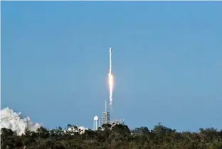  ?? Bruce Weaver / AFP / Getty Images ?? SpaceX’s Falcon 9 rocket lifts off from space launch complex 39A at Kennedy Space Center in Florida on Thursday. SpaceX blasted off a recycled rocket for the first time, using a booster that had previously flown cargo to the Internatio­nal Space Station.