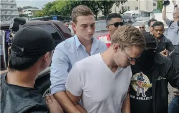  ?? MALAYSIA OUTSTR/AFP/GETTY IMAGES ?? Dylan Snel, centre left, and Canadian Lindsey Petersen, centre right, along with Danielle Petersen and Eleanor Hawkins were fined and will be deported from Malaysia for stripping down and taking pictures on a mountain peak deemed sacred by the Dasun...