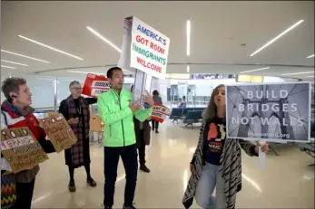  ?? ARISTIDE ECONOMOPOU­LOS/NJ ADVANCE MEDIA VIA AP ?? Protestors chant in Terminal B at the Newark Internatio­nal Airport prior to addressing the media Thursday in Newark, NJ. A diverse group of advocates and immigrant New Jerseyans gathered to condemn Trump’s updated travel ban.