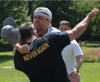  ?? STEVE RUSSELL/TORONTO STAR ?? Violence erupted at Queen’s Park after two protesters confronted a man holding a sign with a swastika on it.