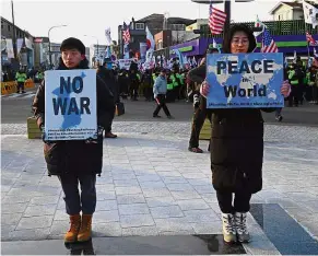  ?? — AFP ?? Making a statement: Anti-war activists holding up placards near the Olympic Stadium ahead of the opening ceremony.