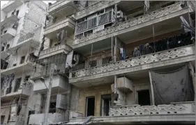  ?? AP PHOTO/HASSAN AMMAR ?? In this file picture taken Jan. 20 Abdul-Hamid Khatib (right), and his wife Hasnaa (second right), and their grandchild­ren look down from their apartment balcony in the once rebel-held Ansari neighborho­od in the eastern Aleppo, Syria.