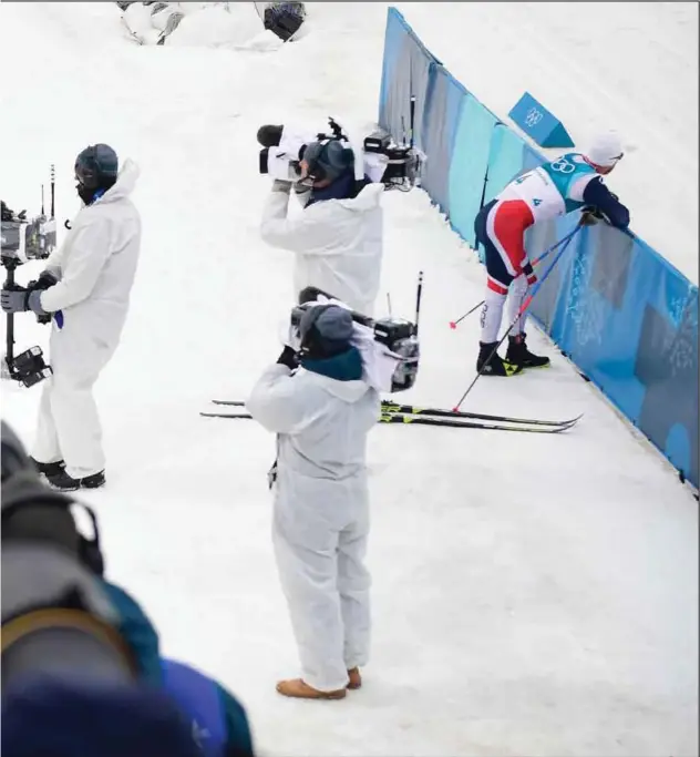  ??  ?? Martin Johnsrud Sundby (til høyre) måtte ha noen minutter for seg selv etter nedturen på OL-femmila. Lagkamerat Hans Christer Holund ligger sliten på snøen etter kraftprøve­n, mens medaljevin­nerne jubler i bakgrunnen.