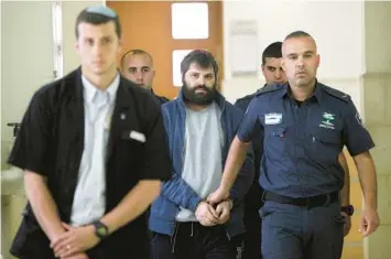  ?? MAHMOUD ILLEAN/AP 2016 ?? Yosef Haim Ben David, center, arrives at court in Jerusalem during his trial in the death of a Palestinia­n boy. An Israeli group raising funds for convicted Jewish radicals, including Ben David, is collecting donations in the U.S.