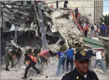  ?? The Associated Press ?? People search for earthquake survivors in a collapsed building in the Roma neighbourh­ood of Mexico City on Tuesday.