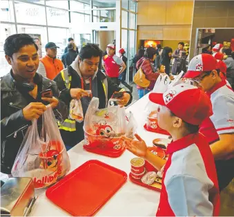  ?? LARRY WONG ?? Hundreds of people queued up for hours outside the Filipino fast food chain Jollibee on Calgary Trail when they opened for business on Friday at 7 a.m.