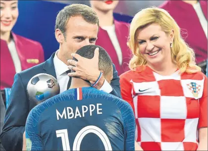  ?? FOTO: AP ?? El presidente francés, Macron, le da el título de mejor joven a Mbappé ante la sonriente presidenta de Croacia, Kolinda Grabar-Kitarovic