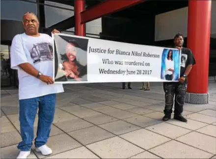  ?? MIKE RELLAHAN – DIGITAL FIRST MEDIA ?? Al Pettigrew, left, and Kim McCrae, family friends of murder victim Bianca Roberson, hold a banner in her honor Thursday morning outside the Chester County Government Services Center ahead of the preliminar­y hearing for the man charged with fatally...