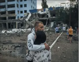  ?? KOSTIANTYN LIBEROV — THE ASSOCIATED PRESS ?? A couple hugs after Russian shelling in Mykolaiv, Ukraine, on Wednesday. According to local media, a supermarke­t, high-rise buildings and pharmacy were damaged.
