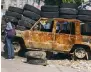  ?? ?? Tyres and a burnt-out car form a roadblock in Port-au-Prince.