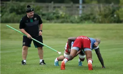  ??  ?? Northampto­n scrum coach Matt Ferguson uses a pole to allow for social distancing during a training session at Franklin’s Gardens on Tuesday. Photograph: David Rogers/Getty Images