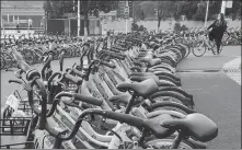  ?? WANG QIMING / FOR CHINA DAILY ?? A rider parks a shared bicycle at a parking lot earmarked for shared bikes in Nanjing, Jiangsu province, in October.