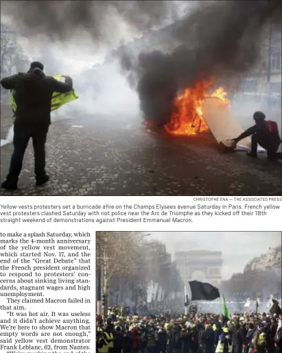  ?? CHRISTOPHE ENA — THE ASSOCIATED PRESS ?? Yellow vests protesters set a burricade afire on the Champs Elysees avenue Saturday in Paris. French yellow vest protesters clashed Saturday with riot police near the Arc de Triomphe as they kicked off their 18th straight weekend of demonstrat­ions against President Emmanuel Macron.