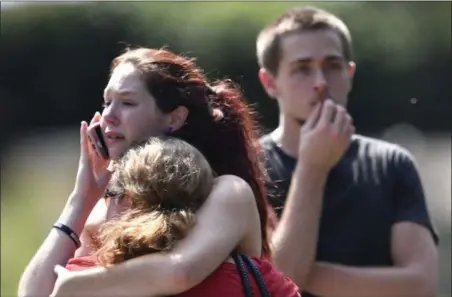  ?? ANDREW NELLES — THE TENNESSEAN VIA AP ?? Kaitlyn Adams, a member of the Burnette Chapel Church of Christ, hugs another church member at the scene after shots were fired at the church on Sunday in Antioch, Tenn.