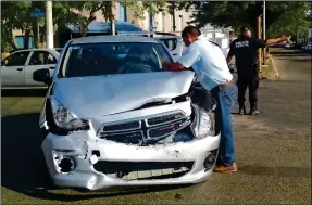  ??  ?? El conductor del Attitude 2015 tras chocar en la Avenida Yucatán. Atrás, un policía estatal guía la vialidad