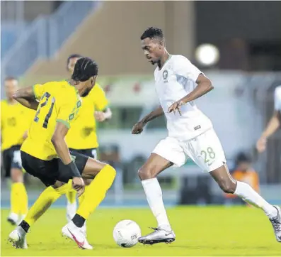  ??  ?? RIYAHI, Saudi Arabia — Jamaica’s Kevon Lambert challenges Mohamed Kanno of the Kingdom of Saudi Arabia during their internatio­nal friendly game on Saturday.