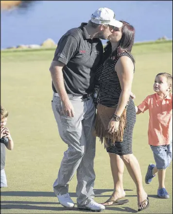  ?? PHELAN M. EBENHACK / AP ?? Marc Leishman gets a congratula­tory kiss from his wife, Audrey, as his children, Oliver, 3, (left) and Harvey, 5, greet him on the 18th green after he won the Arnold Palmer Invitation­al tournament in Orlando, Fla.