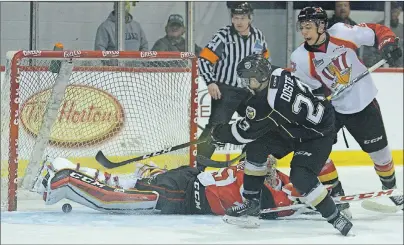  ?? JASON MALLOY/TC MEDIA ?? Charlottet­own Islanders left-winger Alex Dostie slips the puck under Baie-Comeau Drakkar goalie Antoine Samuel’s pad during Saturday’s Quebec Major Junior Hockey League playoff game at the Eastlink Centre. It was his second of three goals on the night.