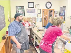  ?? ?? Food bank chef and kitchen manager Yves Dechaine, left, leads a baking class at Greener Village.