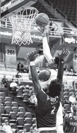  ?? STAFF PHOTO BY ROBIN RUDD ?? UTC’s Kevin Easley scores over Eastern Kentucky’s Jordan Oakley during Saturday’s 81-78 loss at McKenzie Arena. Easley led the Mocs with 22 points.