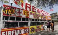  ?? Nick Ut, The Associated Press ?? Customers survey the inventory at a TNT Fireworks stand on Friday in Monterey Park, Calif. With fewer profession­al celebratio­ns on July 4 because of the pandemic, many Americans are bound to shoot off fireworks in backyards and at block parties.