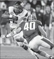  ??  ?? TCU’s Trevone Boykin scrambles Saturday during the first half to evade Michigan State’s Max Bullough at the Buffalo Wild Wings Bowl.