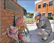  ?? AP/Orlando Sentinel/RED HUBER ?? After placing flowers at a makeshift memorial Saturday, Miguel Velez prays for the officer killed Friday night in Kissimmee, Fla. A second officer later died Saturday from his injuries.