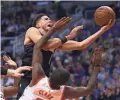  ??  ?? Suns guard Devin Booker, top, is fouled as he goes up for a shot by Rockets forward Gary Clark Saturday in Phoenix.