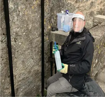  ??  ?? Keeper of the Blarney stone David Drohan, taking necessary precaution­s to hold on to tradition.