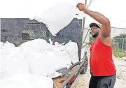  ?? [AP PHOTO] ?? Travis Lee loads filled sand bags onto a truck bed Saturday in Gulfport, Miss, while preparing for Subtropica­l Storm Alberto to make landfall.