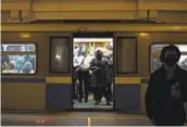  ?? NATALIA KOLESNIKOV­A AFP VIA GETTY IMAGES ?? Commuters wearing face masks stand in a metro train in Moscow on Tuesday.