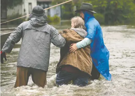  ?? JAY JANNER ASSOCIATED PRESS ?? Des secouriste­s aident une femme évacuée de sa maison, à Beaumont, à se rendre à bord d’un bateau de sauvetage. Cette ville du Texas a encore reçu 50cm de précipitat­ions durant la nuit de mardi à mercredi.