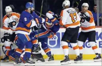  ?? ADAM HUNGER — THE ASSOCIATED PRESS ?? The Flyers’ Wayne Simmonds (17) throws Islanders center Mathew Barzal Barzal scored a goal during the second period in New York on Tuesday. to the ice after