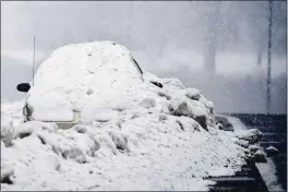  ?? ANDREW NELLES — THE TENNESSEAN VIA AP ?? An abandoned car is covered in snow on the shoulder of Briley Parkway in Nashville, Tenn., Thursday.