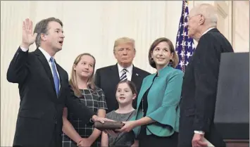  ?? Susan Walsh / Associated Press ?? In this Oct. 8 photo, Trump, center, listens as retired Supreme Court Justice Anthony Kennedy, right, ceremonial­ly swears-in Supreme Court Justice Brett Kavanaugh, left, as Kavanaugh’s wife Ashley and daughters Margaret, left, and Liza look on.